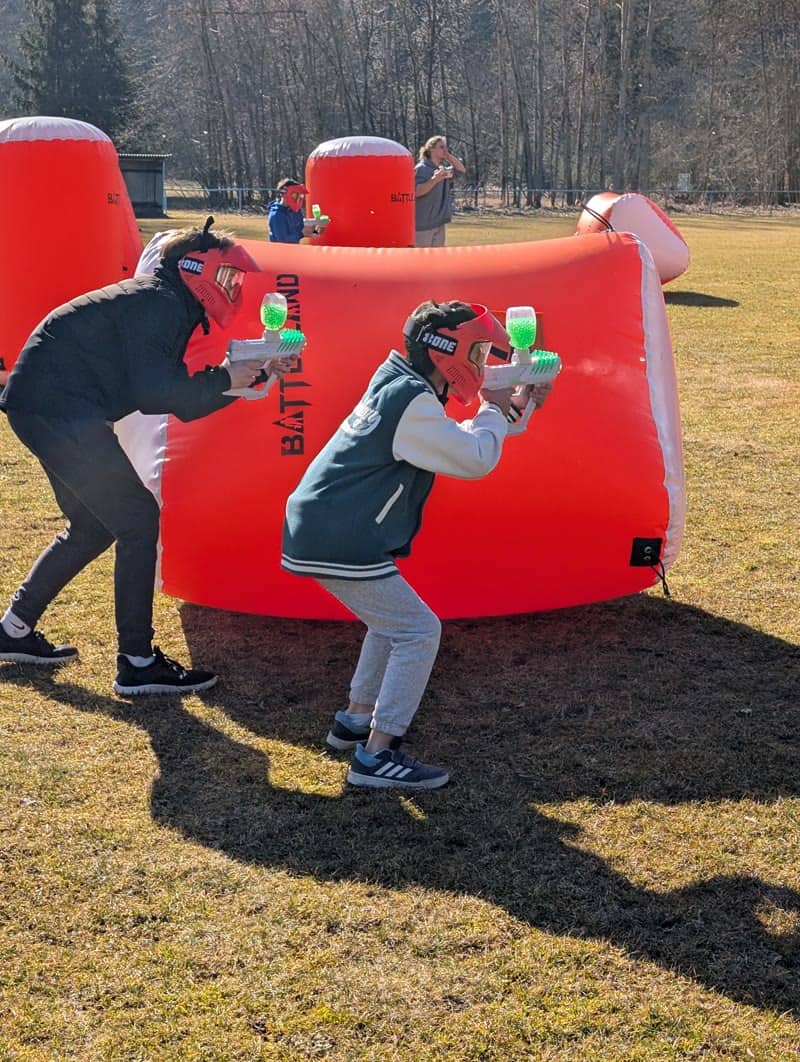 Dva hráči s gel blastery za nafukovací překážkou